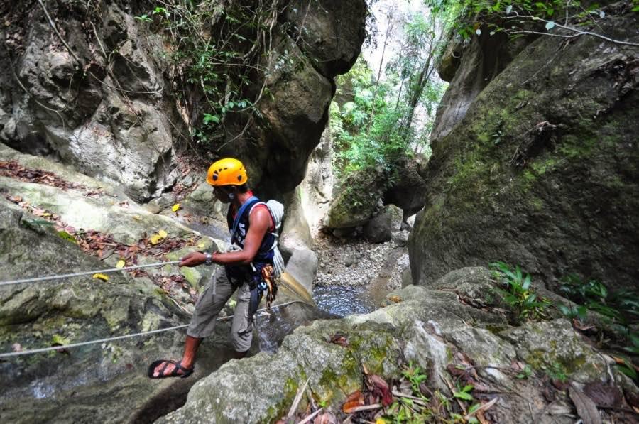 An adrenaline junkie rappels carefully down the canyons of MoalBoal